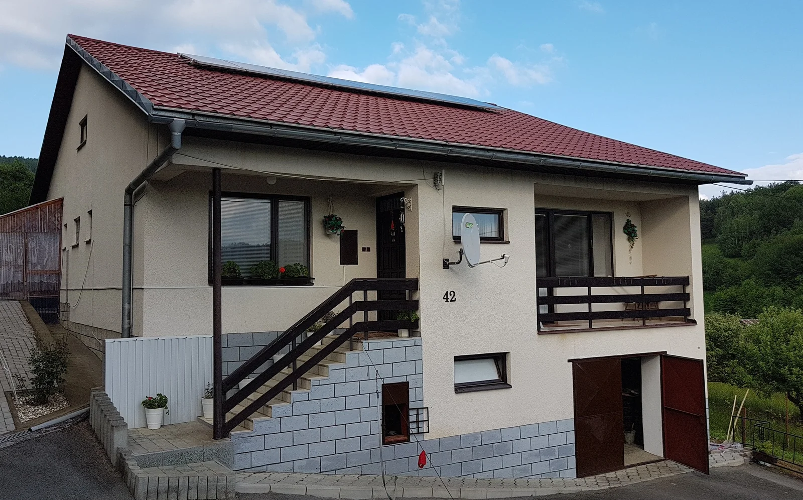Fotovoltické panely na červenej sedlovej streche rodinného domu